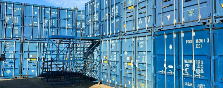 Blue 3-5 year old shipping containers stacked on top of each other